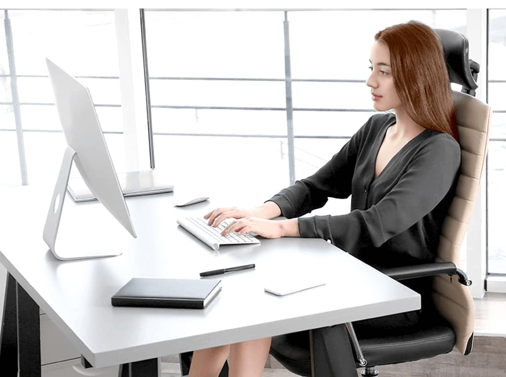 Person practicing proper posture at a desk, representing ergonomic habits to prevent neck pain, as advised by a Linwood chiropractor